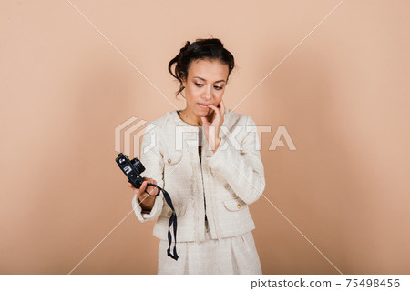 Attractive african american black female, using a slr digital camera taking photographs in studio. 75498456