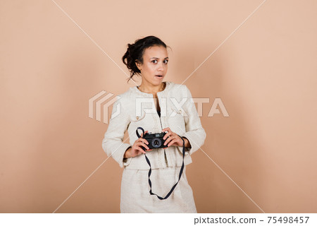 Attractive african american black female, using a slr digital camera taking photographs in studio. 75498457
