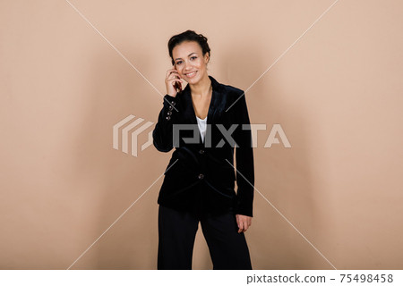 Successful young business woman with hands folded smiling over grey background 75498458