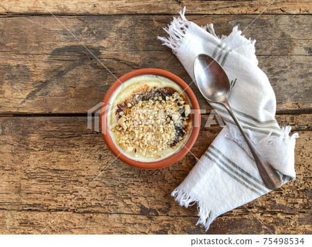 bowl of baked rice pudding that is a traditional Turkish dessert on wooden table 75498534