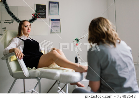 Photo of the professional pedicure process with the model Photo of the professional pedicure process with the model 75498548