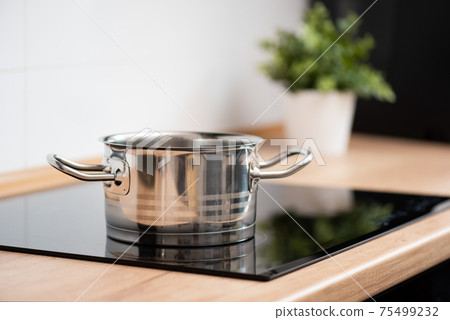 Pot in the kitchen on the induction hob Pot in the kitchen on the induction hob 75499232