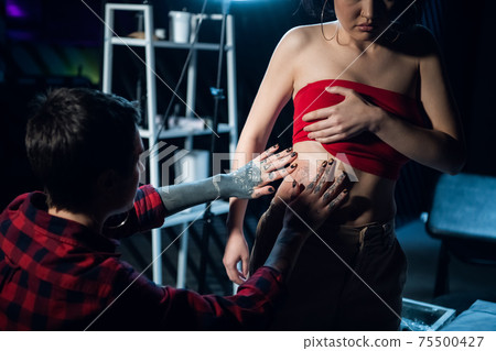 In the tattoo parlor, the master has finished filling the tattoo and is sealing it with a film for faster healing 75500427