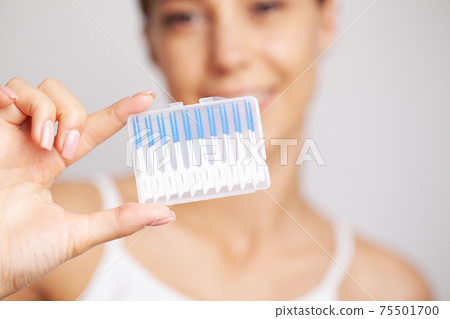 The woman uses brushes to clean the interdental spaces The woman uses brushes to clean the interdental spaces 75501700