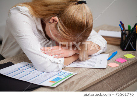 Tired business woman working with documents in the office at the desk Tired business woman working with documents in the office at the desk 75501770