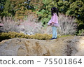 Back view of a girl standing in abundant nature 75501864