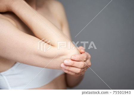 Middle-aged Japanese woman suffering from elbow problems 75501943