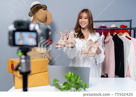 woman selling shoes and clothes online by camera live streaming, business online e-commerce at home woman selling shoes and clothes online by camera live streaming, business online e-commerce at home 75502420