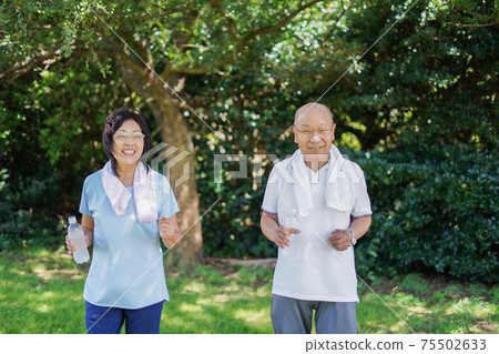 Elderly couple running outdoors 75502633