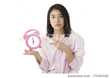woman holding alarm clock feeling sleepy woman holding alarm clock feeling sleepy 75504160