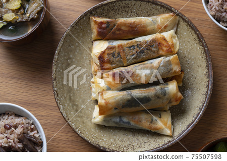 Spring rolls of perilla and chicken fillet, and a table of cooked rice 75507598
