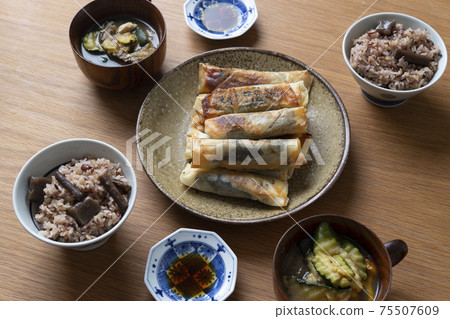 Spring rolls of perilla and chicken fillet, and a table of cooked rice 75507609