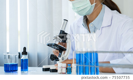 scientists researching in laboratory in white lab coat, gloves analysing, looking at test tubes sample, biotechnology concept 75507735
