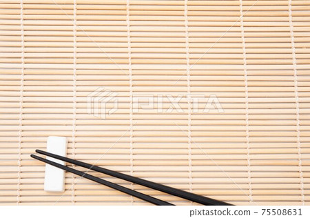 Chopsticks resting on bamboo sushi mat. Japanese traditional concept 75508631