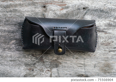 Genuine black cow leather glasses case on wood 75508904