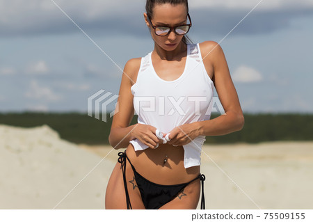 Beautiful female in tank top on beach 75509155