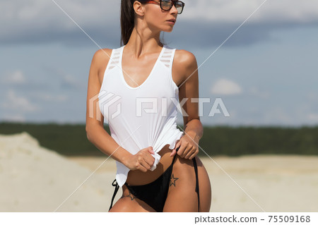 Beautiful female in tank top on beach 75509168