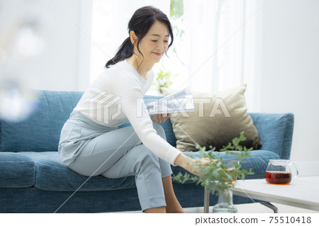 Woman relaxing in the living room 75510418