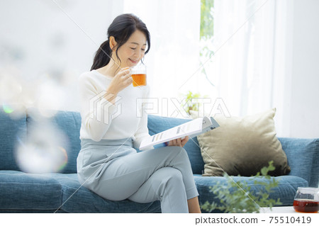 Woman relaxing in the living room 75510419