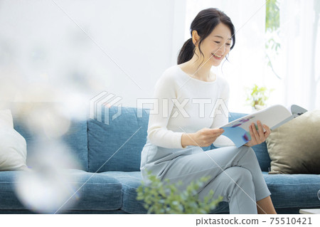 Woman relaxing in the living room 75510421