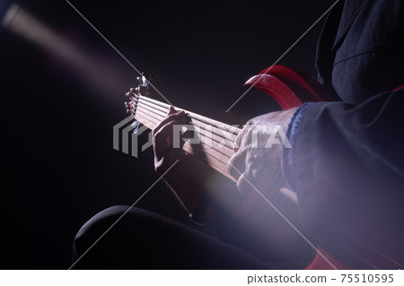 Male musician playing six-string fretless bass guitar Male musician playing six-string fretless bass guitar 75510595