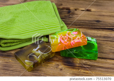 Set of handmade soap bars and towel on wooden background Set of handmade soap bars and towel on wooden background 75513070