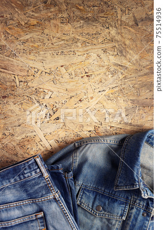Denim jeans on chipboard wooden background texture Denim jeans on chipboard wooden background texture 75514936