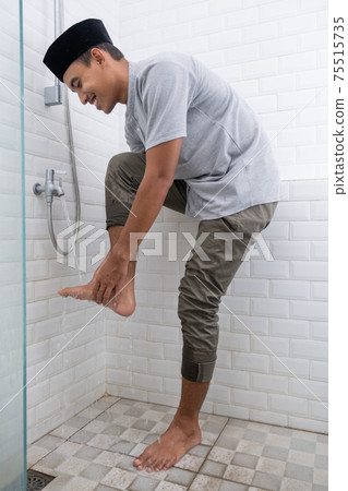 Young Muslim man perform ablution wudhu before prayer at home Young Muslim man perform ablution wudhu before prayer at home 75515735