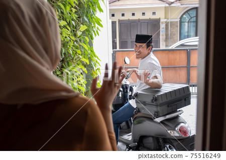 asian husband waving goodbye to his wife before leaving out by motorcycle asian husband waving goodbye to his wife before leaving out by motorcycle 75516249