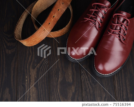 brown men's boots, jeans and belt on wooden background brown men's boots, jeans and belt on wooden background 75516394