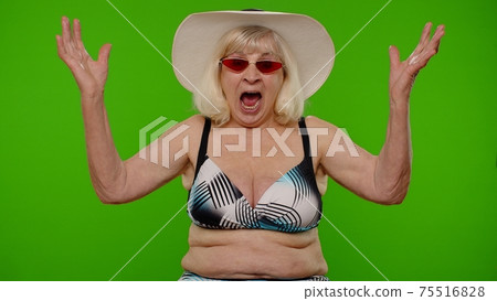 Senior woman tourist raising hand in victorious gesture, dancing shouting Yes, celebrating success 75516828