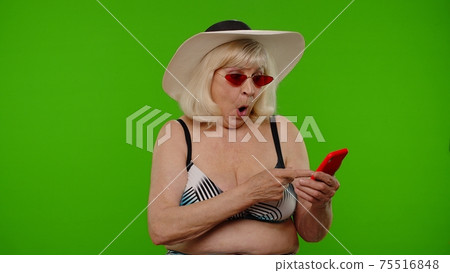 Senior woman tourist browsing on mobile phone app, looking for resort hotel on chroma key background Senior woman tourist browsing on mobile phone app, looking for resort hotel on chroma key background 75516848