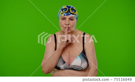 Elderly woman tourist holding finger near lips for silence sign, hush, secret, silence on chroma key 75516849