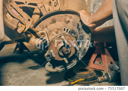 Car Mechanic Remove Car Wheel Hub and Drive Axle and Brake Caliper in Vintage Tone Car Mechanic Remove Car Wheel Hub and Drive Axle and Brake Caliper in Vintage Tone 75517087