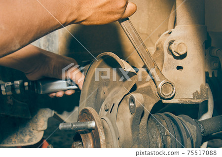 Car Mechanic or Auto Mechanic Loosen Shock Absorber Bolt by Wrench in Vintage Tone Car Mechanic or Auto Mechanic Loosen Shock Absorber Bolt by Wrench in Vintage Tone 75517088