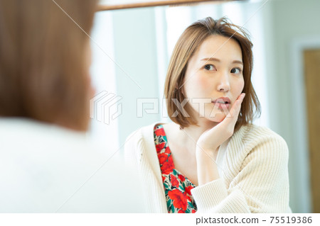 Beautiful woman looking in the mirror Beautiful woman looking in the mirror 75519386