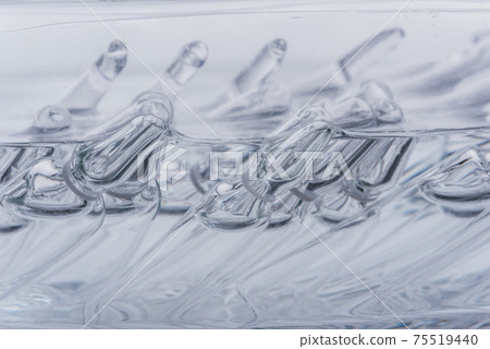 Glass medical ampoule vial for injection. Medicine is liquid sodium chloride with of aqueous solution in ampulla. Close up. Bottles ampule multicolor. Glass medical ampoule vial for injection. Medicine is liquid sodium chloride with of aqueous solution in ampulla. Close up. Bottles ampule multicolor. 75519440