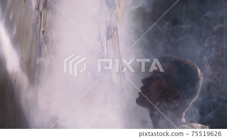 Artist designer draws an eagle on the wall. Craftsman decorator paints a picture with acrylic oil color. Vaper smokes vape. Dark magic cinematic look. Artist designer draws an eagle on the wall. Craftsman decorator paints a picture with acrylic oil color. Vaper smokes vape. Dark magic cinematic look. 75519626