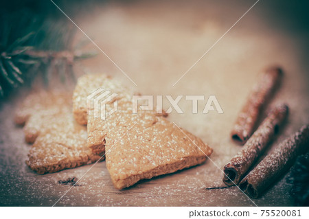 cinnamon sticks, cookies and Christmas tree branch but the table cinnamon sticks, cookies and Christmas tree branch but the table 75520081