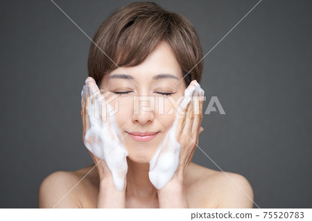 Middle-aged Japanese woman washing face with foam 75520783