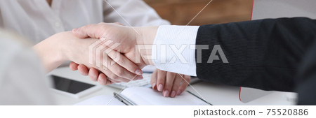 Businessman and woman shake hands as hello in office 75520886