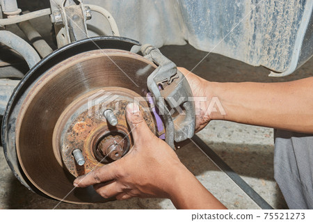 Car Mechanic Assemble Brake Caliper to Wheel Hub 75521273