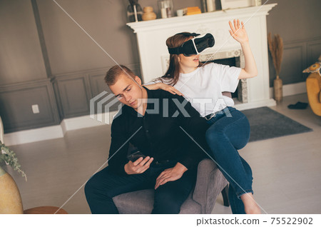Young man and woman Using VR In The Living Room 75522902