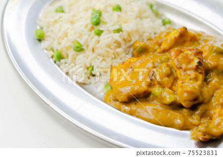Roasted chicken breast pieces in a mildly spiced coconut curry sauce with fried rice with peas and egg Roasted chicken breast pieces in a mildly spiced coconut curry sauce with fried rice with peas and egg 75523831
