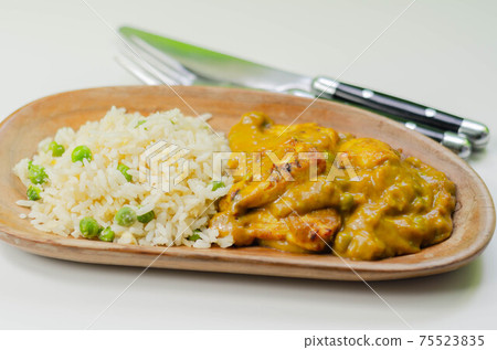 Roasted chicken breast pieces in a mildly spiced coconut curry sauce with fried rice with peas and egg Roasted chicken breast pieces in a mildly spiced coconut curry sauce with fried rice with peas and egg 75523835