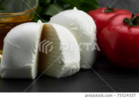 Fresh handmade soft Italian cheese from Campania, white balls of buffalo mozzarella cheese made from cow milk ready to eat close up Fresh handmade soft Italian cheese from Campania, white balls of buffalo mozzarella cheese made from cow milk ready to eat close up 75524337