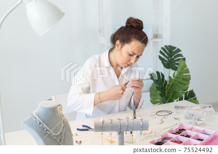 Professional jewelry designer making handmade jewelry in studio workshop. Fashion, creativity and handmade concept Professional jewelry designer making handmade jewelry in studio workshop. Fashion, creativity and handmade concept 75524492