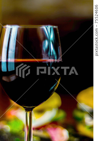 Red wine in a wine glass, celebration of a moment with a glass of wine, exquisite liquor for gourmets Red wine in a wine glass, celebration of a moment with a glass of wine, exquisite liquor for gourmets 75524686
