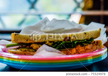 chicken breast in tikka spices, served with onion bhaji, crisp spinach and crunchy cucumber, all in sandwich 75524978
