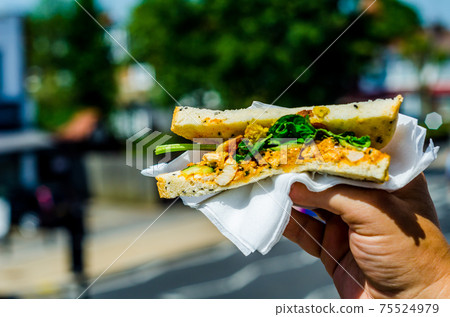 chicken breast in tikka spices, served with onion bhaji, crisp spinach and crunchy cucumber, all in sandwich 75524979